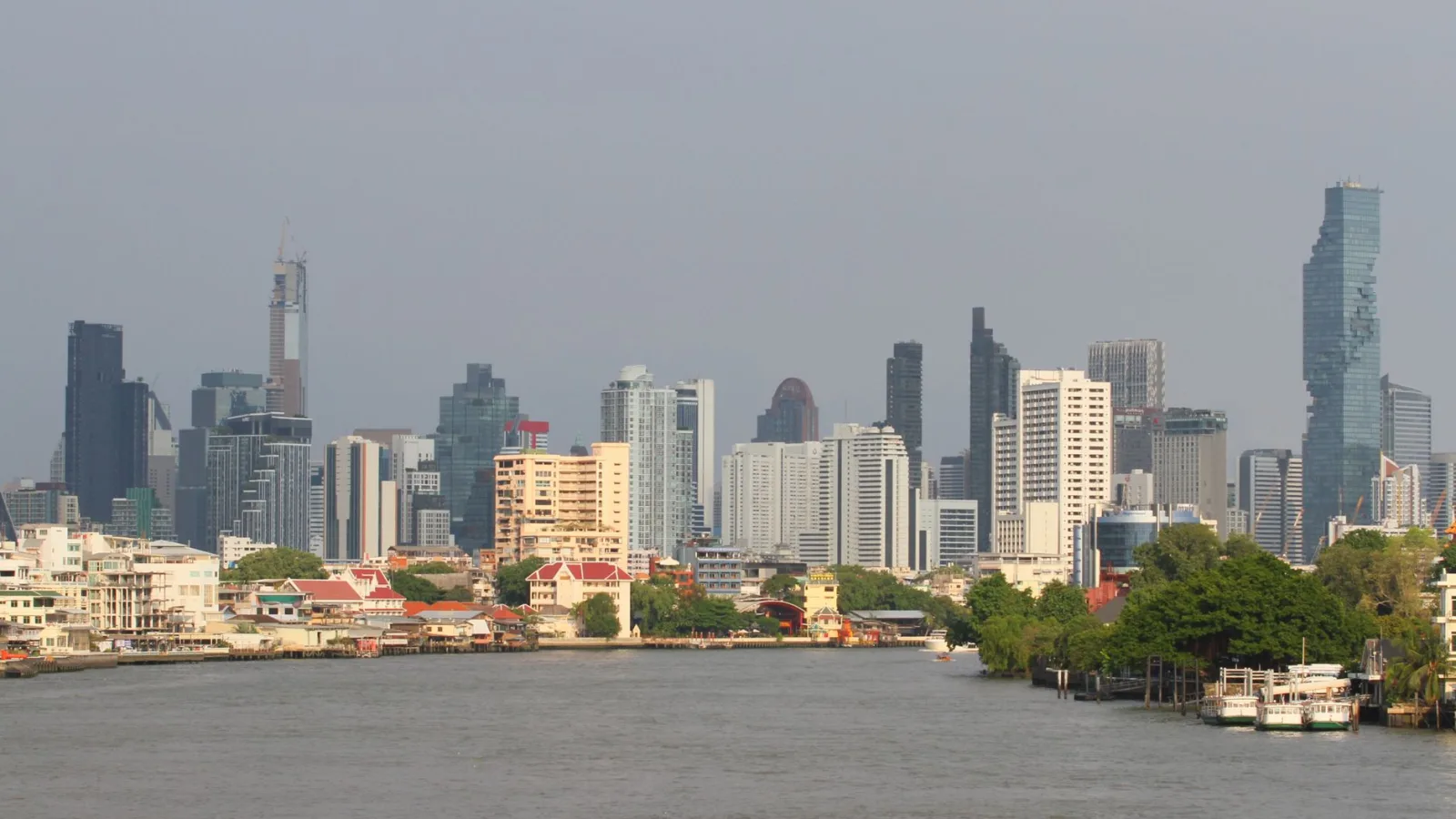 Bangkok's skyline with modern skyscrapers along the Chao Phraya River.