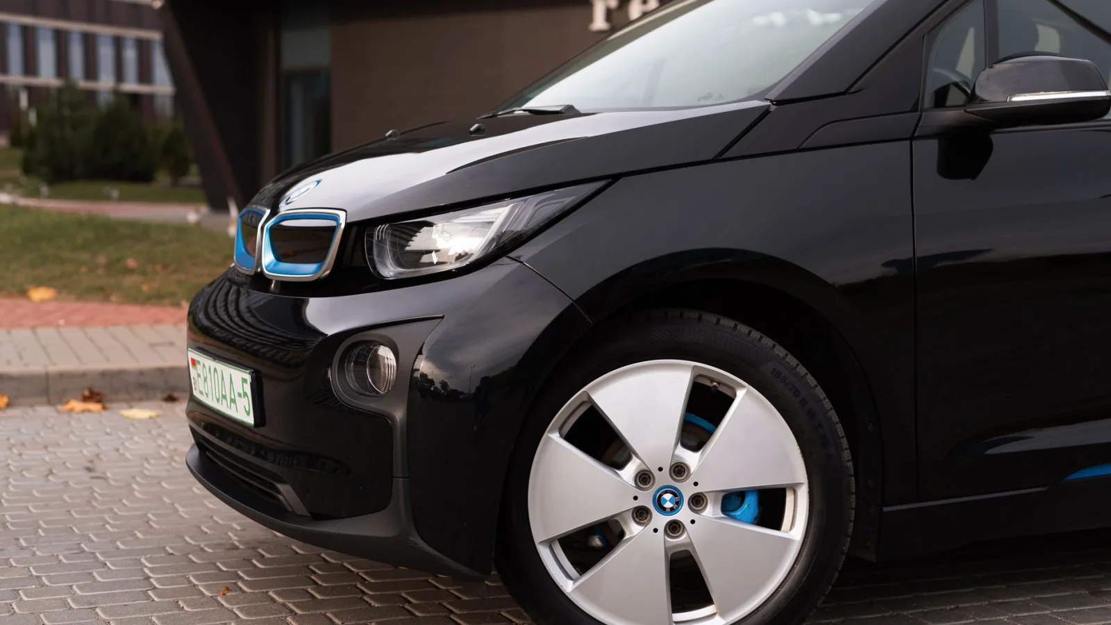 Detailed shot of a black electric BMW car parked in an urban area.