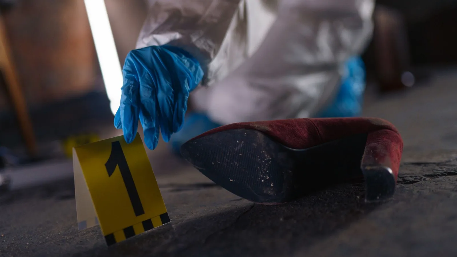 Crime scene investigation with shoe as evidence marked with number one and forensic glove.