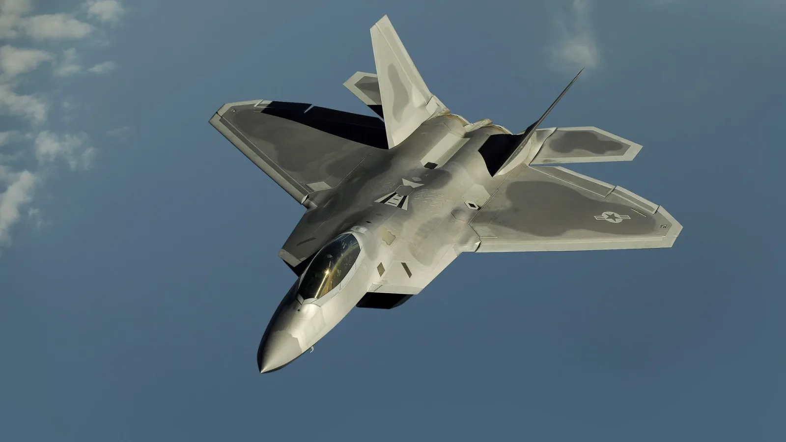 Powerful military aircraft soaring against a calm blue sky.