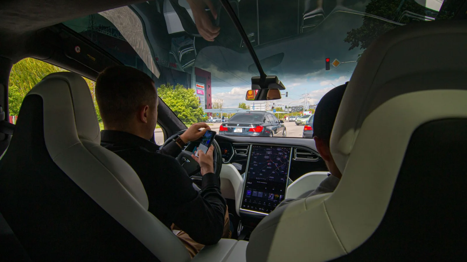 Inside a Tesla vehicle in city traffic, showcasing modern technology and urban driving.